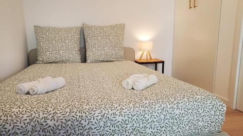 a bedroom with a bed with two towels on it at Le Balcon Cosy - Centre Clermont in Clermont-Ferrand