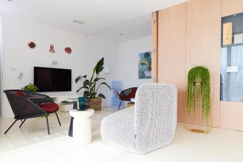 a living room with a white chair and a tv at Villa Alma Vista in Dobrovo