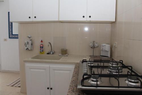 a kitchen with a stove and a sink at Résidence Chahed in Hammam Sousse