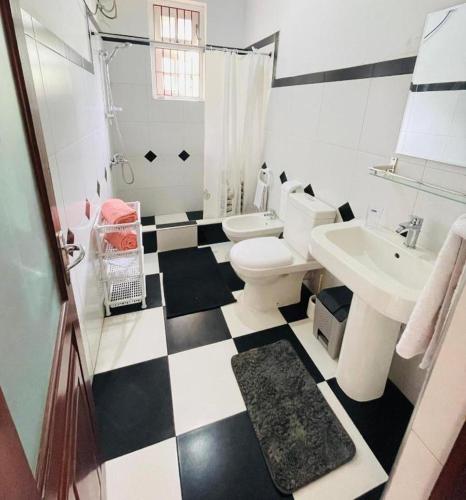 a bathroom with a black and white checkered floor at SAN Holiday Villa in Wadduwa
