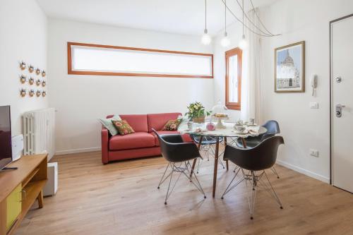a living room with a table and a red couch at Laguna Boutique Apartments in Mestre