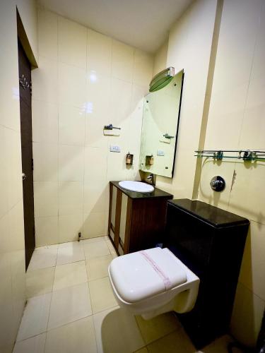 a bathroom with a toilet and a sink and a mirror at Hotel Cosmos in Lucknow