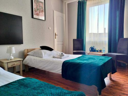 a hotel room with two beds and a window at KAMIENICA Pokoje & Restauracja in Opalenica