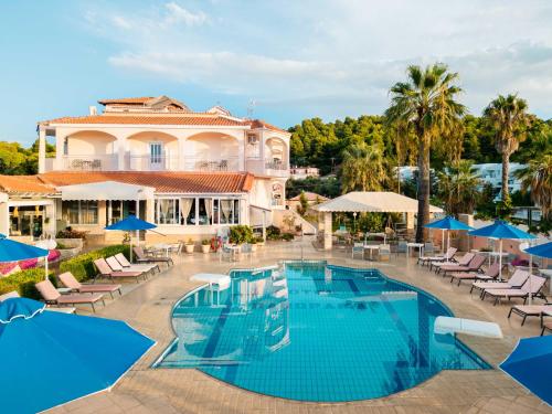 a resort with a pool and chairs and umbrellas at Hotel Panorama in Koukounaries
