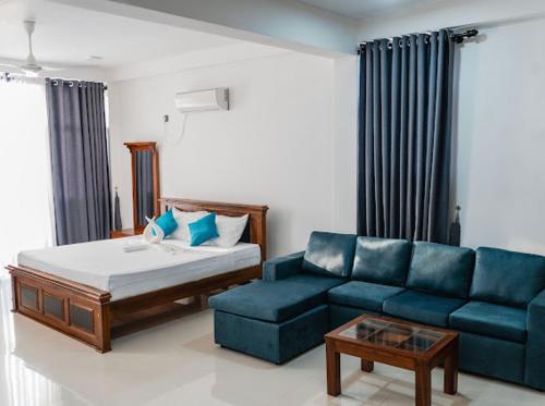 a living room with a couch and a blue sofa at Ocean River View in Ambalangoda