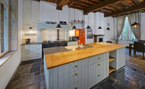 a large kitchen with a wooden counter top at One Magnific 3 floors Authentic Dutch House with Terrace and One 2 bedrooms Deluxe modern apartment in Maastricht