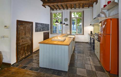 a kitchen with an orange refrigerator and a counter at One Magnific 3 floors Authentic Dutch House with Terrace and One 2 bedrooms Deluxe modern apartment in Maastricht