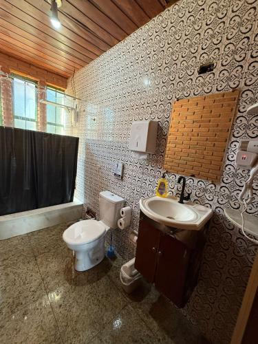 a bathroom with a toilet and a sink at Quarto confortável no Centro in Botucatu