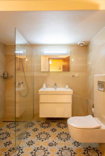 a bathroom with a toilet and a sink and a shower at Aurora Apartment in Afitos