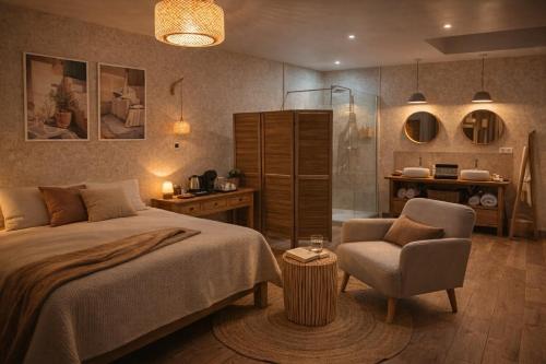 a bedroom with a bed and a chair and a shower at Le Jardin d'Elusa in Eauze