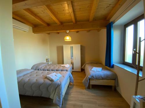 a bedroom with three beds in a room with a window at Casale La Rosa Azzurra in Ponte Buggianese