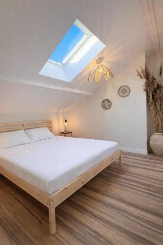a bedroom with a large bed with a skylight at Les hébergements Rousseau in Oyonnax