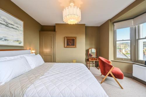 a bedroom with a bed and a chandelier and a chair at Hastings View in Hastings