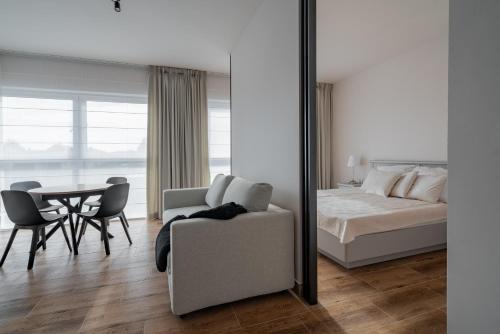 a bedroom with a bed and a table and a mirror at Apartamenty Szelągowskiej in Raszyn