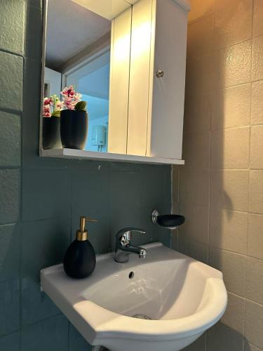 a bathroom with a sink and a mirror and flowers at SO SIMPLE mouresi in Mouresi
