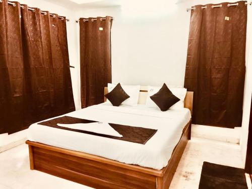 a bedroom with a bed with black curtains at HoTEL K7 in Chennai