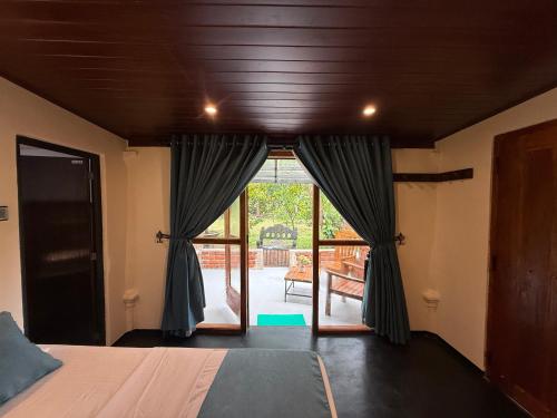 a bedroom with a bed and a sliding glass door at Sigiriya Lantern Homestay in Sigiriya