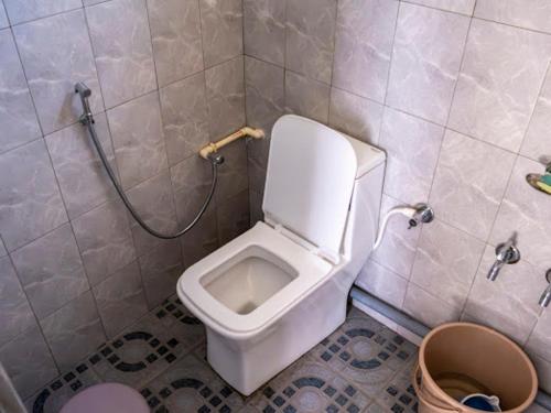 a bathroom with a white toilet and a shower at Teecee in Āīzawl