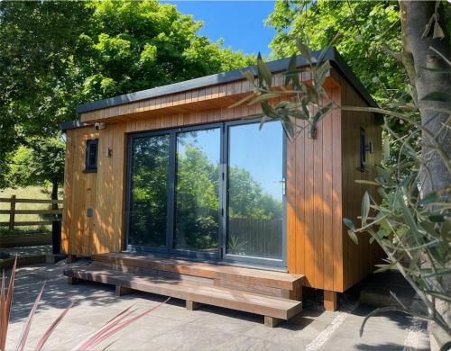 a tiny house with a large window on a patio at Barefoot Beach Hut in Skegness