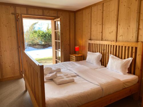 a bedroom with a large bed with a window at Chalet Rosablanche in Veysonnaz