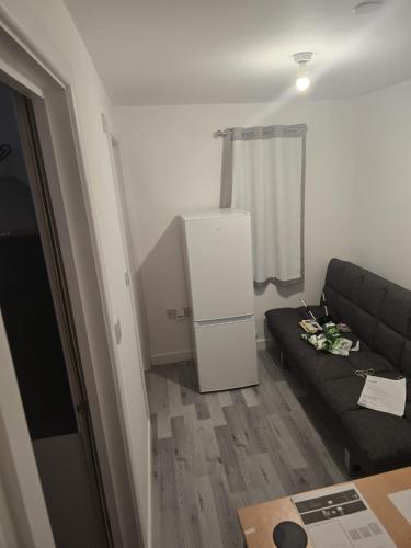 a living room with a couch and a refrigerator at Kissingers Lodge in Bridgend