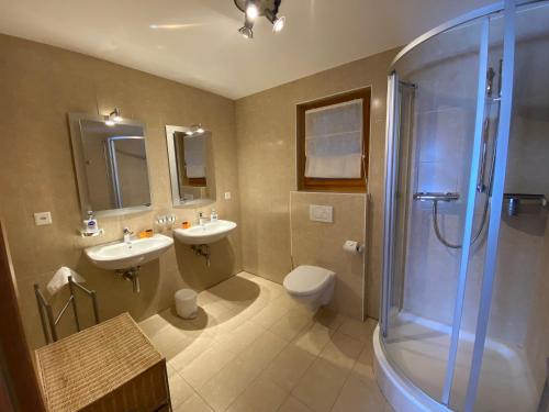 a bathroom with two sinks and a shower and a toilet at Chalet Rosablanche in Veysonnaz
