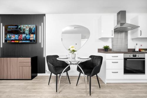 a kitchen with a table with two chairs and a mirror at Stylish Apartment - Twin Beds - Parking - Fast Wi-Fi 9CC in Birmingham