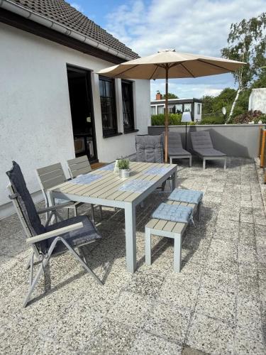 a table and chairs and an umbrella on a patio at Strandgut- unsere Große in Dranske