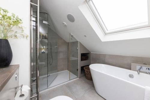a bathroom with a bath tub and a shower at Pet-Friendly Luxury Home The Butler Collection in Brighton & Hove
