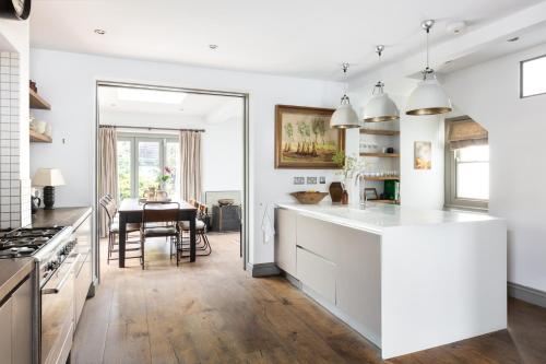 a kitchen with white cabinets and a dining room at Pet-Friendly Luxury Home The Butler Collection in Brighton & Hove