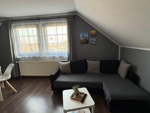 a living room with a couch and a table at Strandgut- unsere Kleine in Dranske