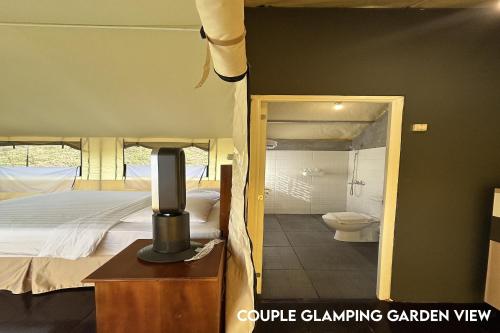 a bedroom with a bed and a bathroom with a toilet at Alinson Sunset Hill in Bogor