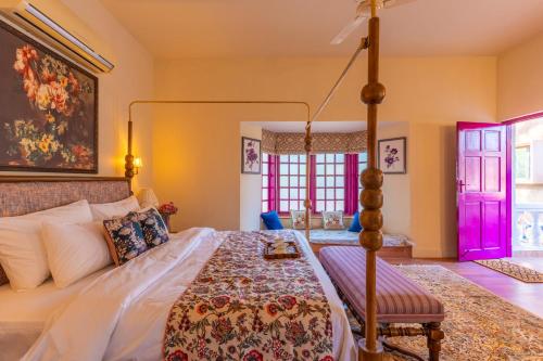 a bedroom with a canopy bed and a chair at Seclude Hampi 1800 in Sandūr