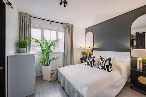a bedroom with a bed and two potted plants at SleepLuxury ApartHOUSE in Glasgow