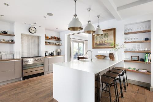 a kitchen with a large white island with bar stools at Pet-Friendly Luxury Home The Butler Collection in Brighton & Hove