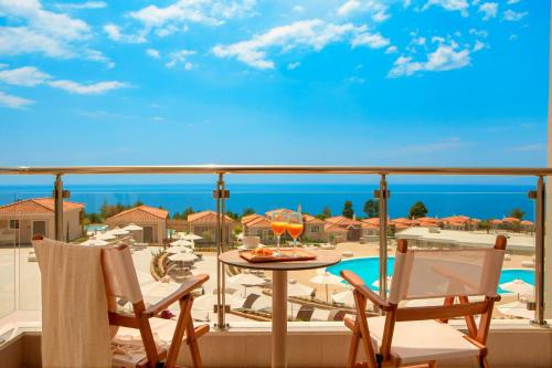 a balcony with a table and chairs and a pool at Zeus Eleva Ajul in Agia Paraskevi