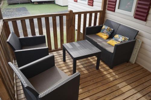 a porch with two chairs and a table at Mobile home 8 personnes in Sérignan