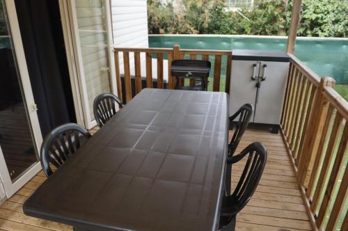 a table on a porch with two chairs at Mobile home 8 personnes in Sérignan