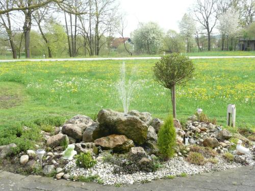 a garden with a fountain in the middle of a field at Ferienwohnungen Tweraser in Bad Birnbach