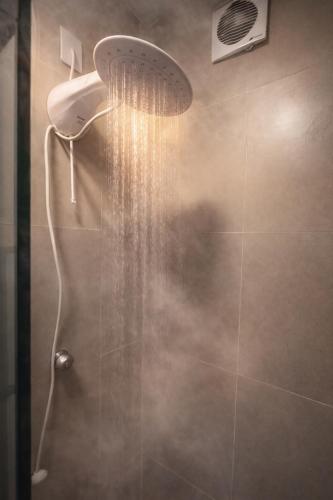 a shower with a shower head in a bathroom at Studio Romã térreo com cozinha in Curitiba