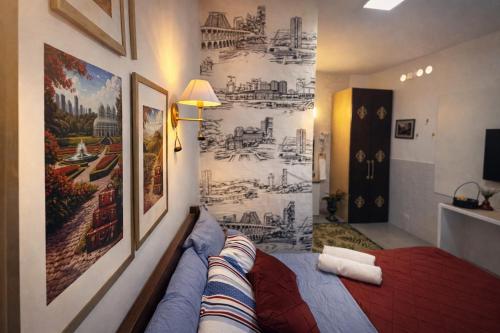 a room with a bed and a wall with a mural at Studio Romã térreo com cozinha in Curitiba