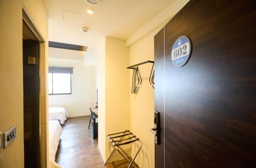a room with a door with a club sign on it at Traveller Inn - Rail Haus in Taitung City