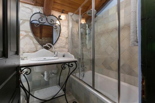a bathroom with a shower and a sink and a mirror at Villa Lida Aresti by Sealand Villas in Agios Leon