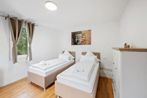 a living room with white furniture and a window at Ramoni Apartments - Bad Wildbad in Bad Wildbad