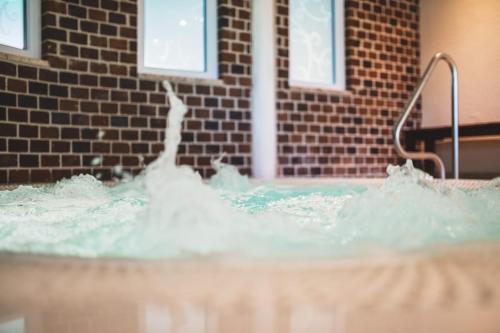 a jacuzzi tub with water coming out of it at Schlossgasthof Rösch in Blaibach