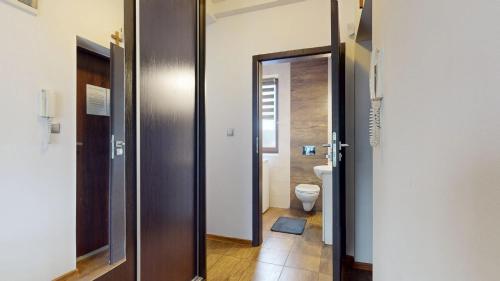 a bathroom with a door leading to a toilet at Apartament Fibra Latte in Rybnik