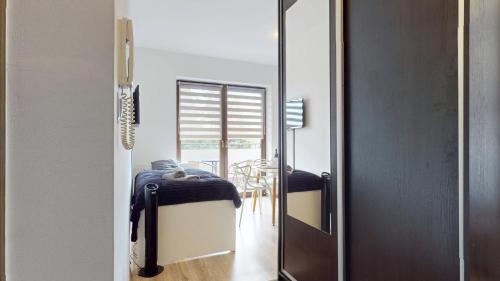 a mirror in a room with a bed and a table at Apartament Fibra Latte in Rybnik