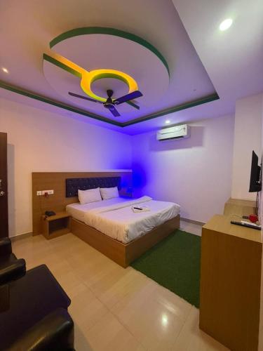 a bedroom with a bed and a ceiling with a ceiling fan at Hotel Glitter in Guwahati