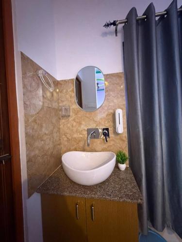 a bathroom with a sink and a mirror on a counter at Hotel Glitter in Guwahati