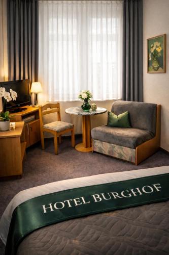 a hotel room with a bed and a living room at Burghof Hotel in Schwarzatal